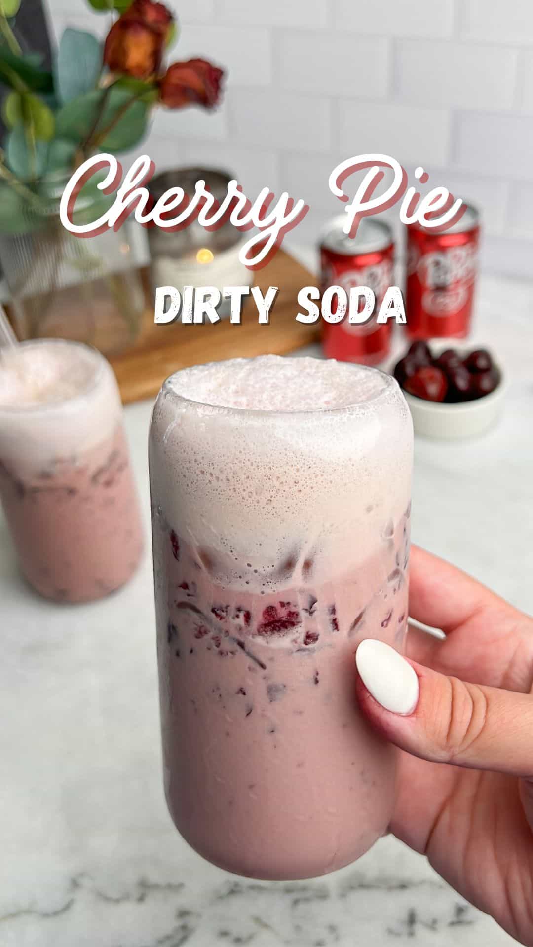 cherry vanilla drink with cold foam held in hand