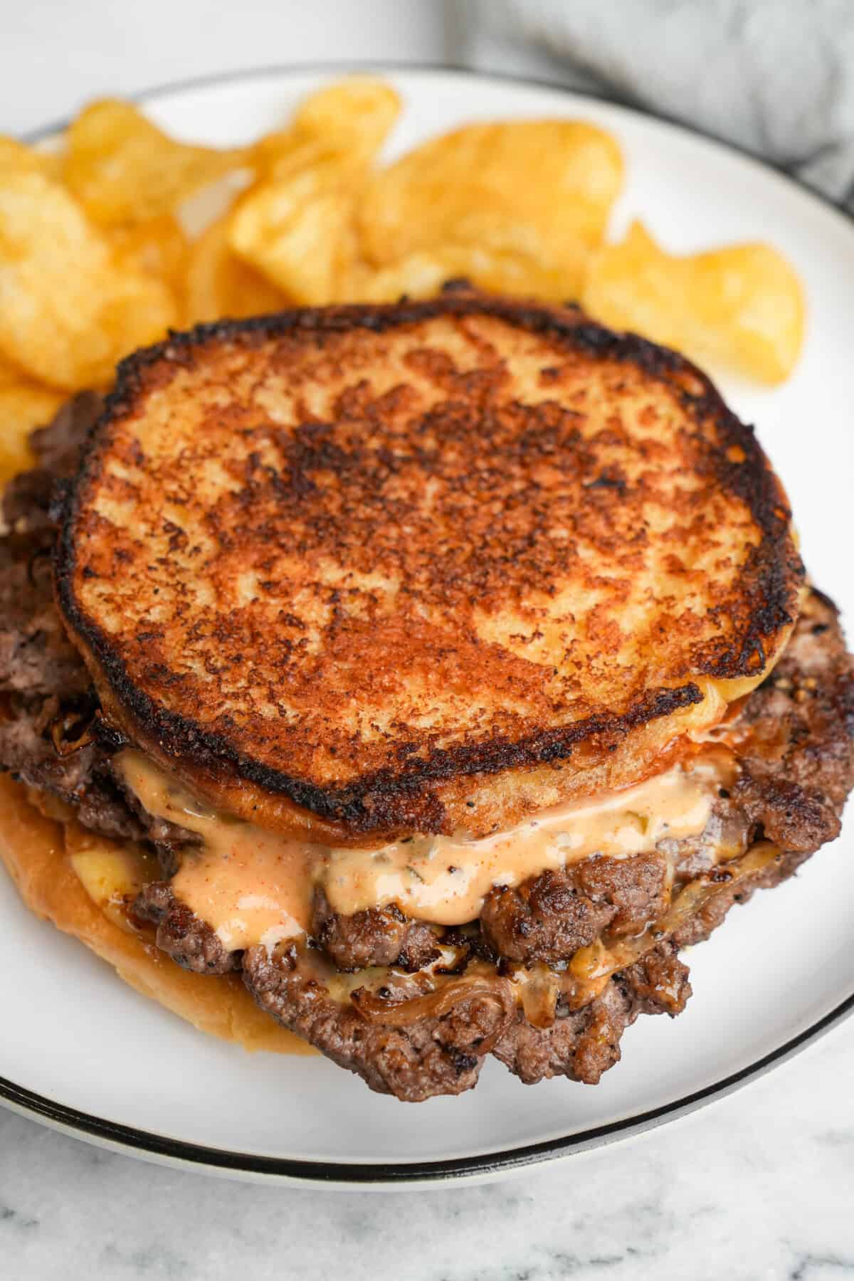 smashburger sandwich on a plate with chips