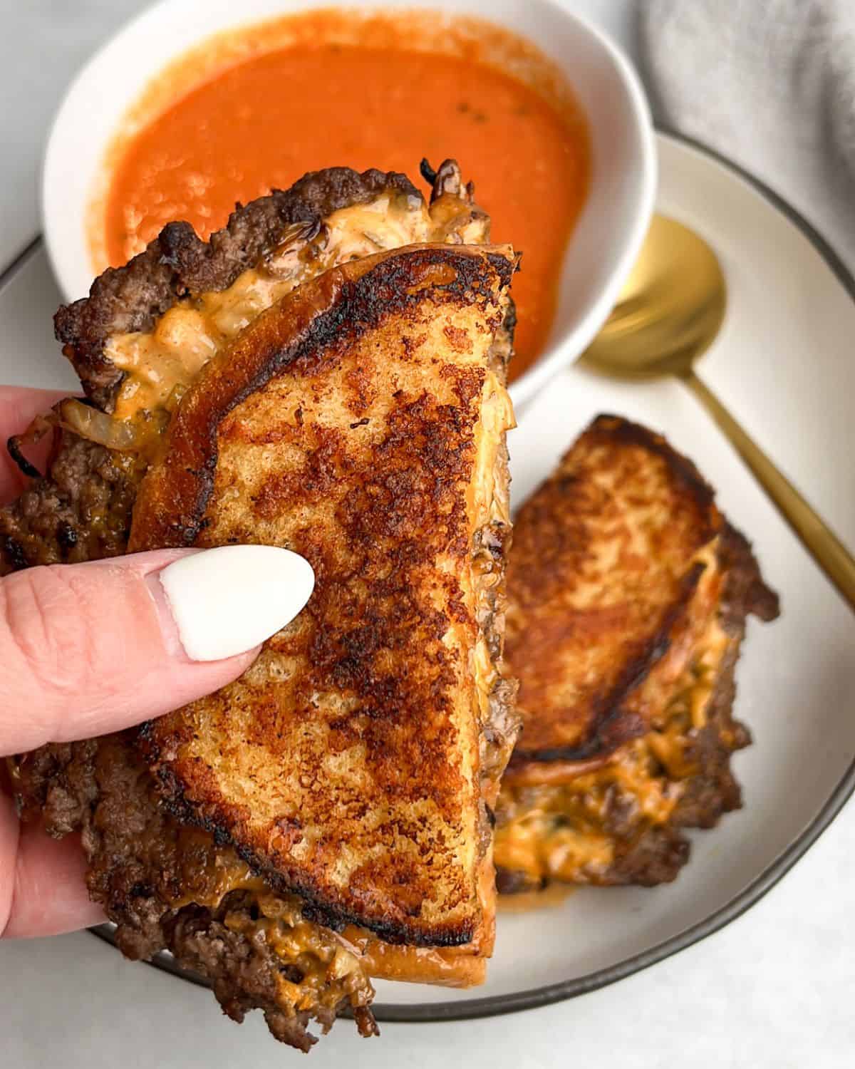 smashburger grilled cheese on a plate with tomato soup