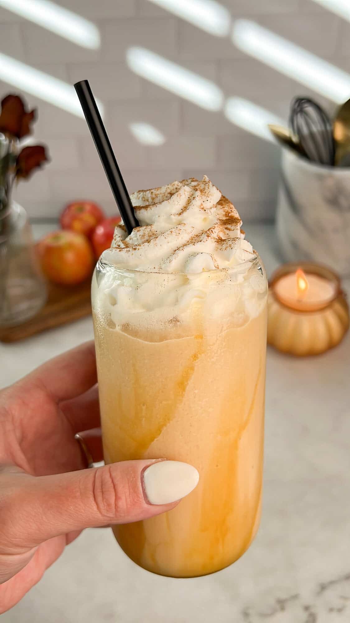 whipped caramel apple cider held in hand