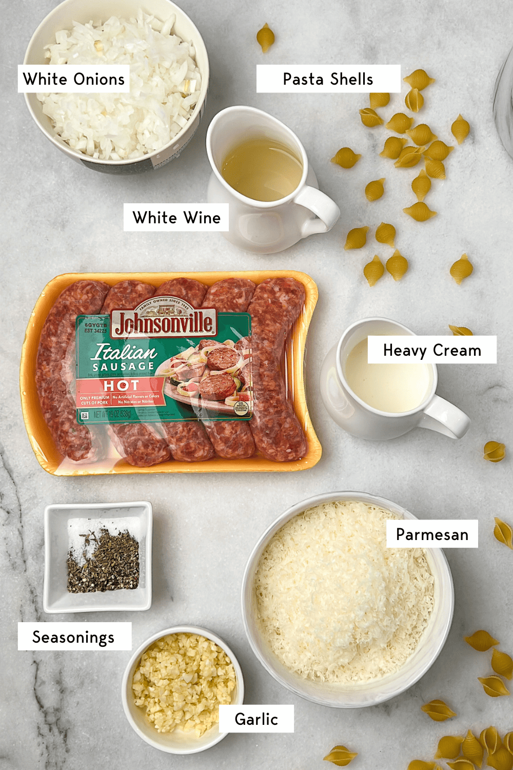 This creamy, spicy Italian sausage pasta comes together in just 30 minutes, and the luscious, cheesy white wine sauce is to die for. Labeled ingredients for Italian sausage pasta.