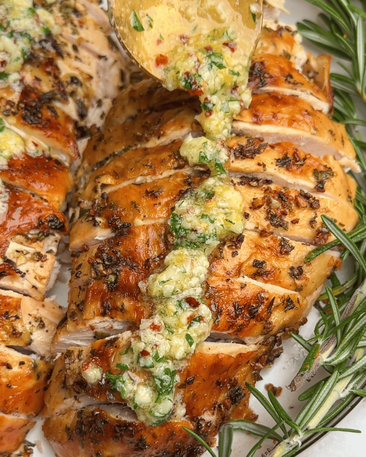 spooning garlic butter over the turkey