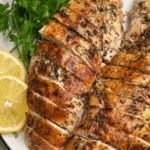 roasted turkey breasts on a plate with lemon and parsley