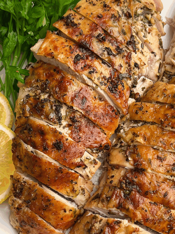 roasted turkey breasts on a plate with lemon and parsley