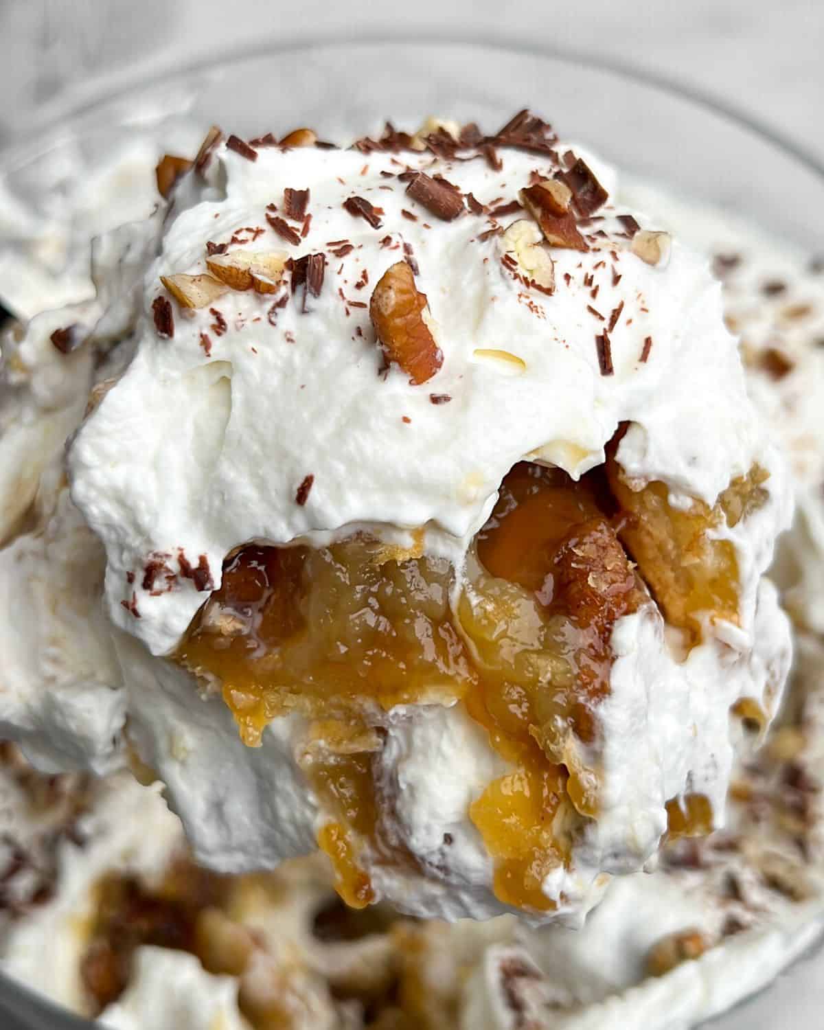 a scoop of whipped cream and pecan pie on a spoon