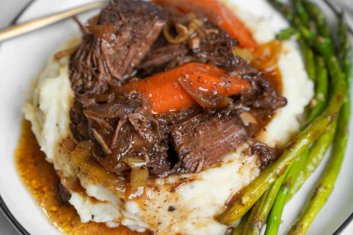 up close image of pot roast and juices over mashed potatoes