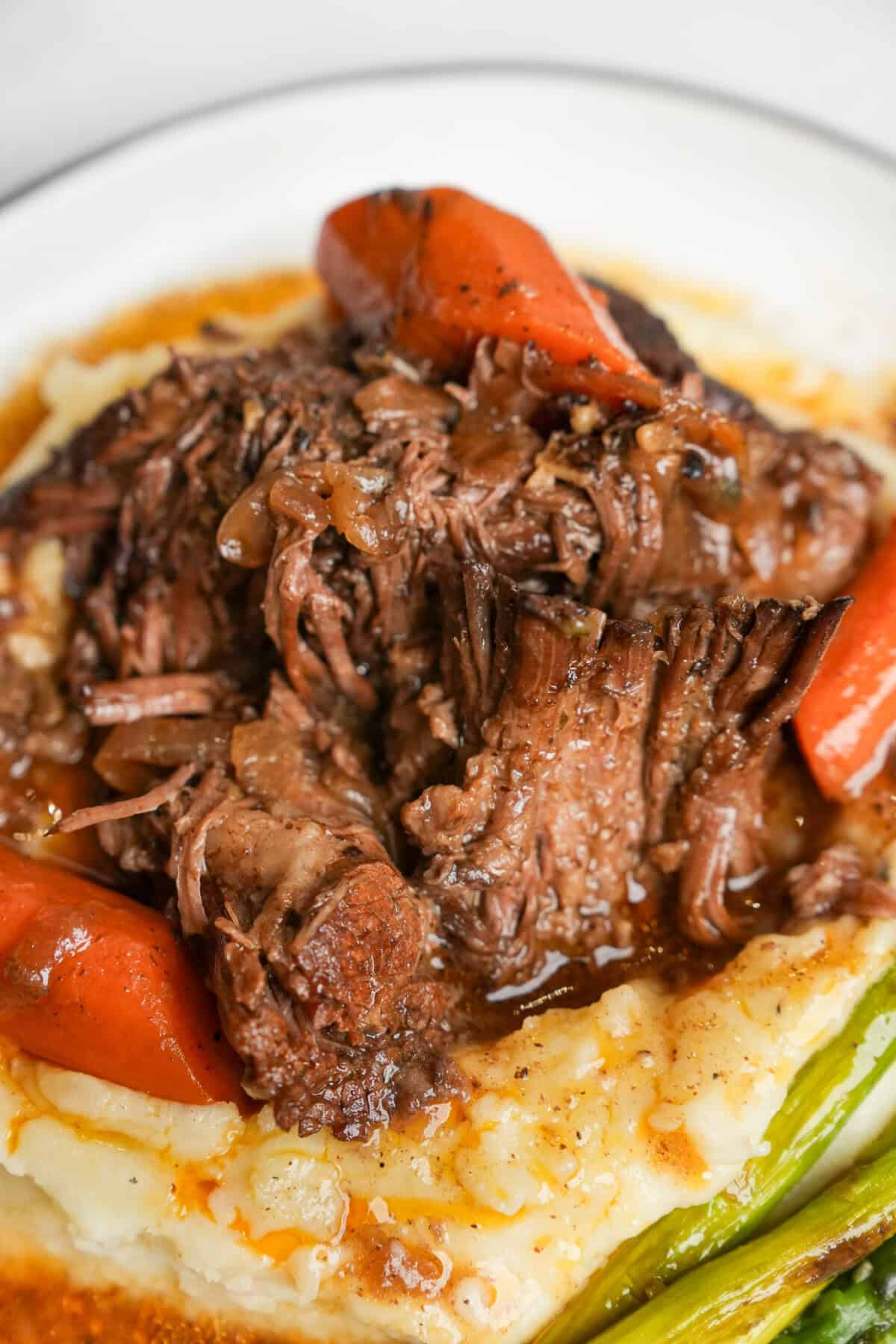 Mississippi pot roast recipe on mashed potatoes up close showing caramelization on the meat