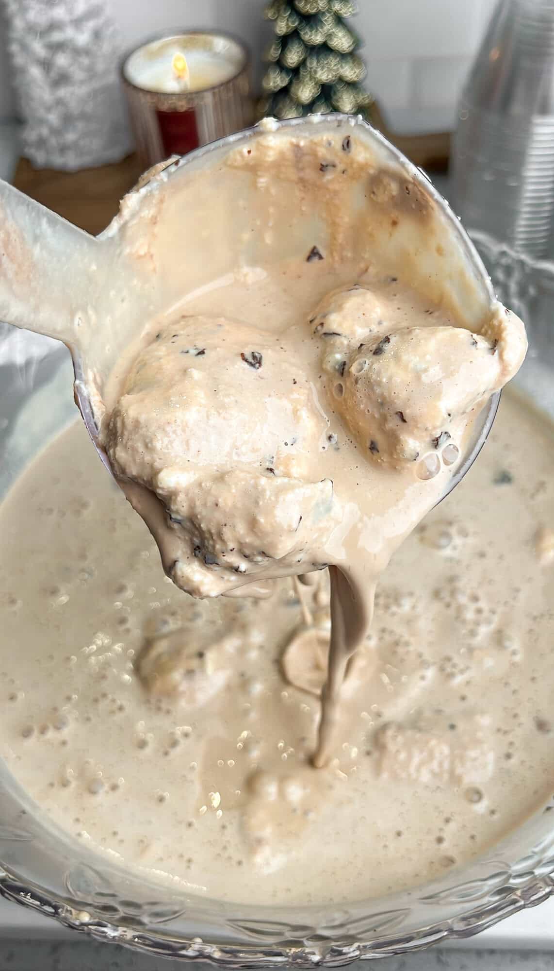 ice cream punch pouring from ladle over a punch bowl