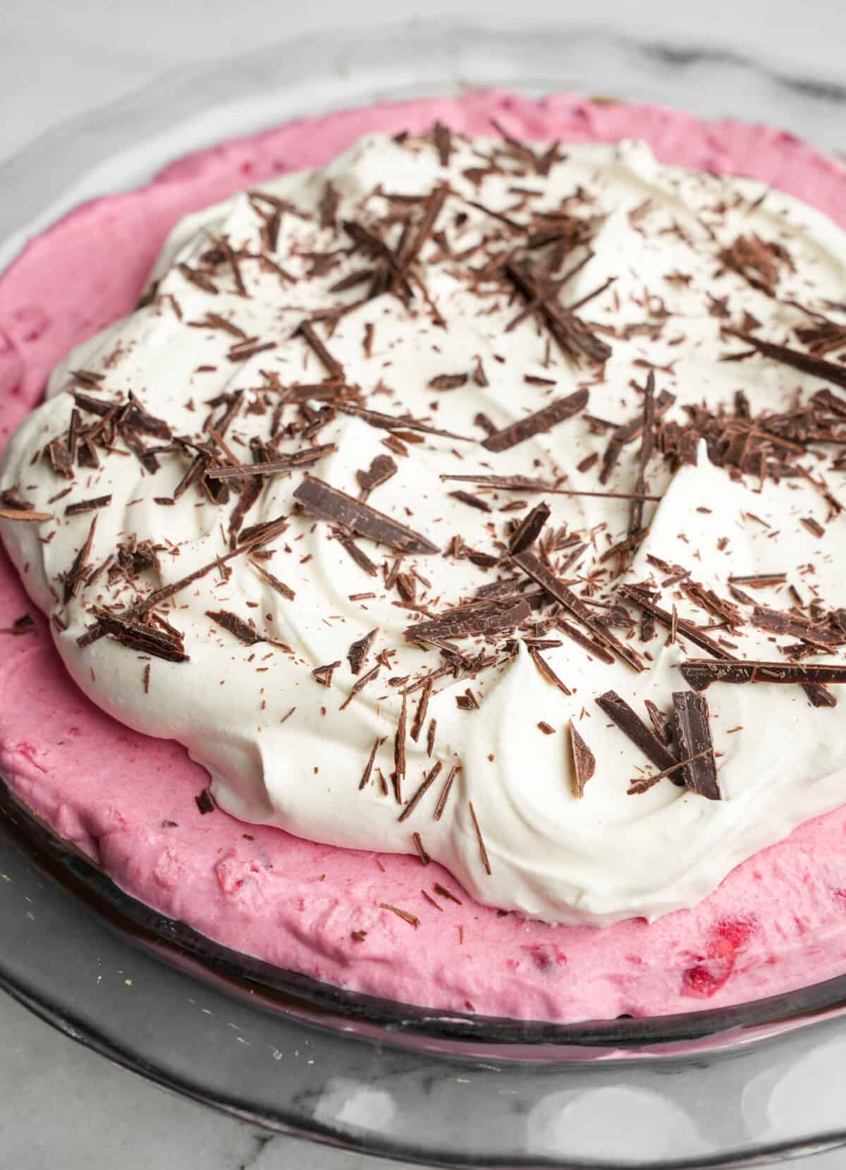 whipped cream and chocolate piled high on cranberry cream pie