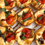 Overhead close up of baked caprese bites drizzled with balsamic glaze