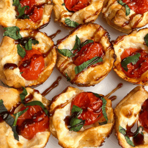 Overhead close up of baked caprese bites drizzled with balsamic glaze