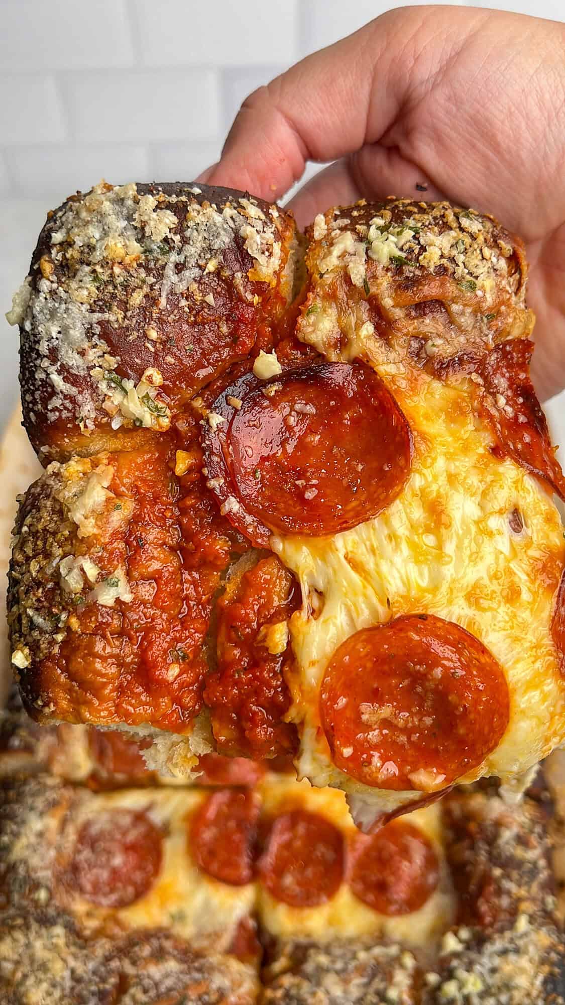 square slice of pizza on hawaiian rolls