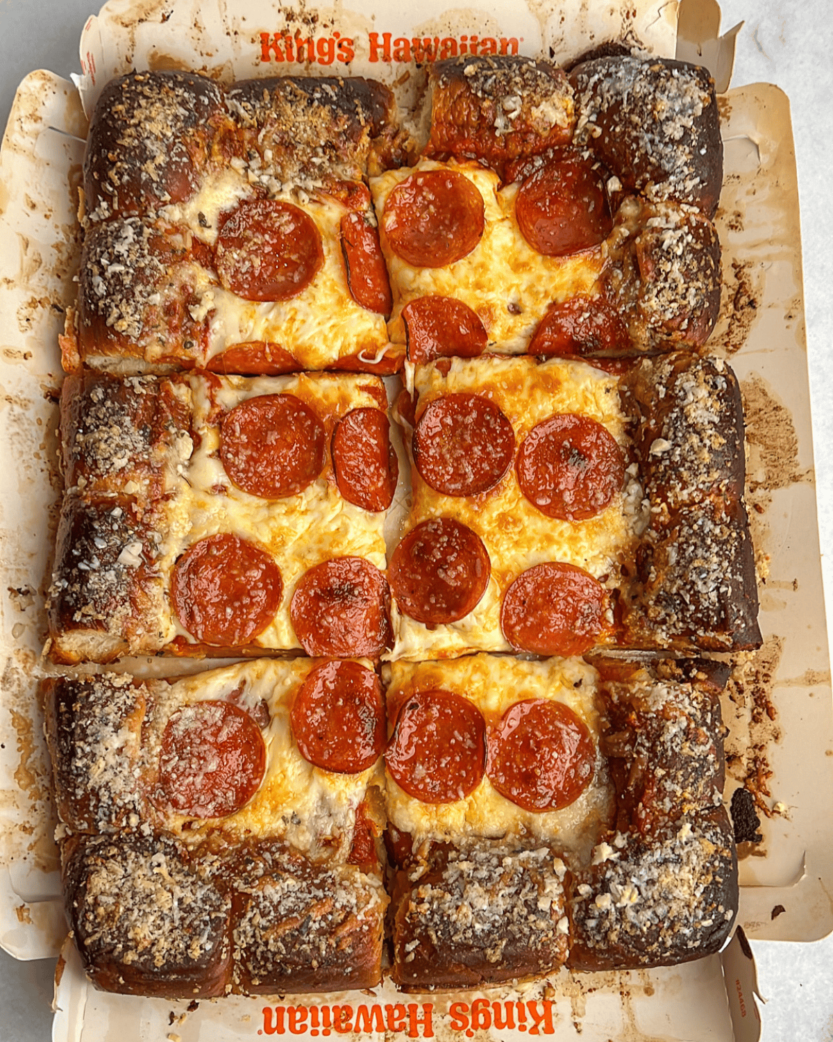 a sliced pepperoni pizza using hawaiian rolls as the crust