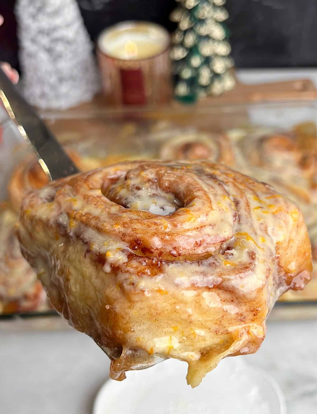 cinnamon roll on a spatula being plated