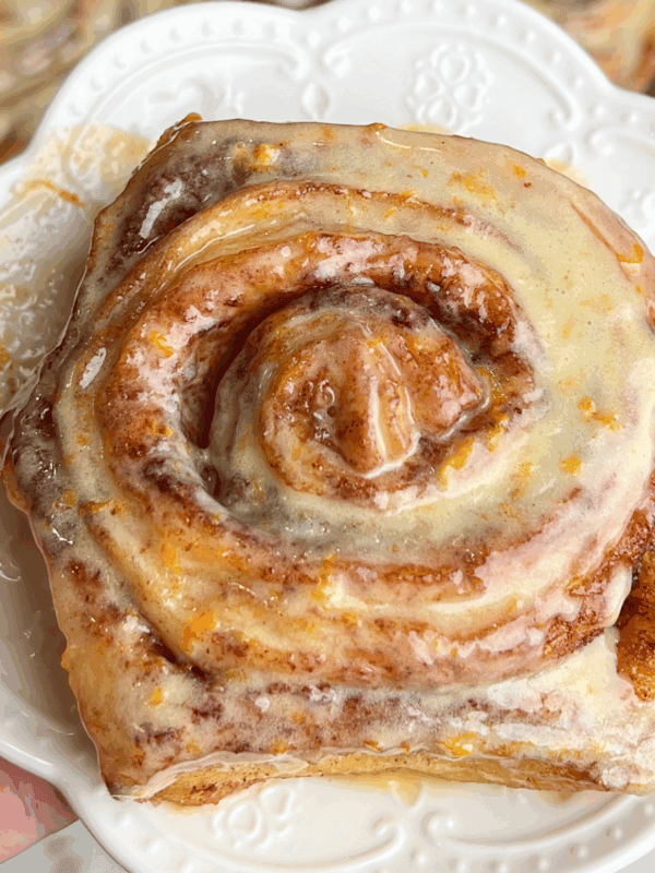 orange cinnamon roll on a dessert plate