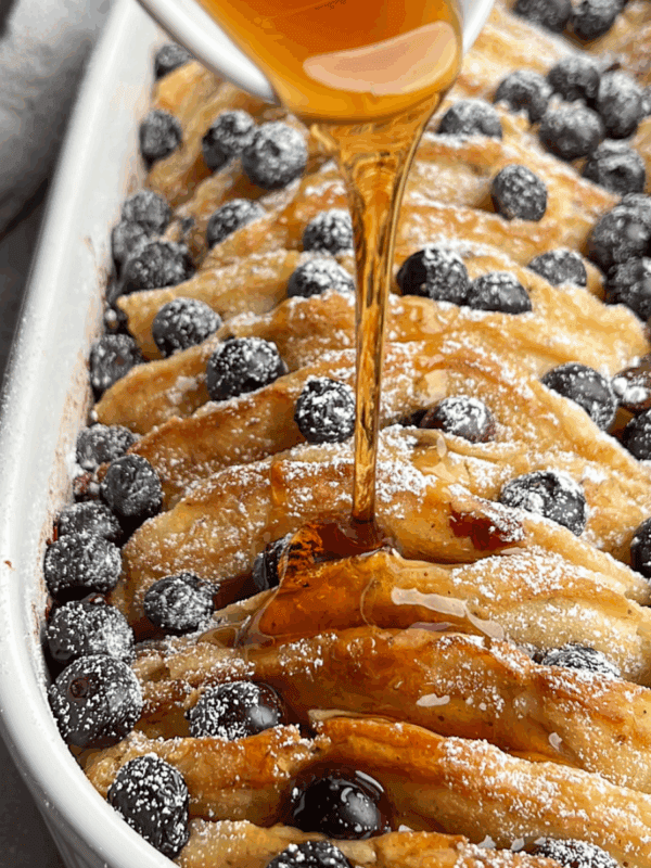 featured image for pancake casserole with warm syrup drizzling over the pancakes