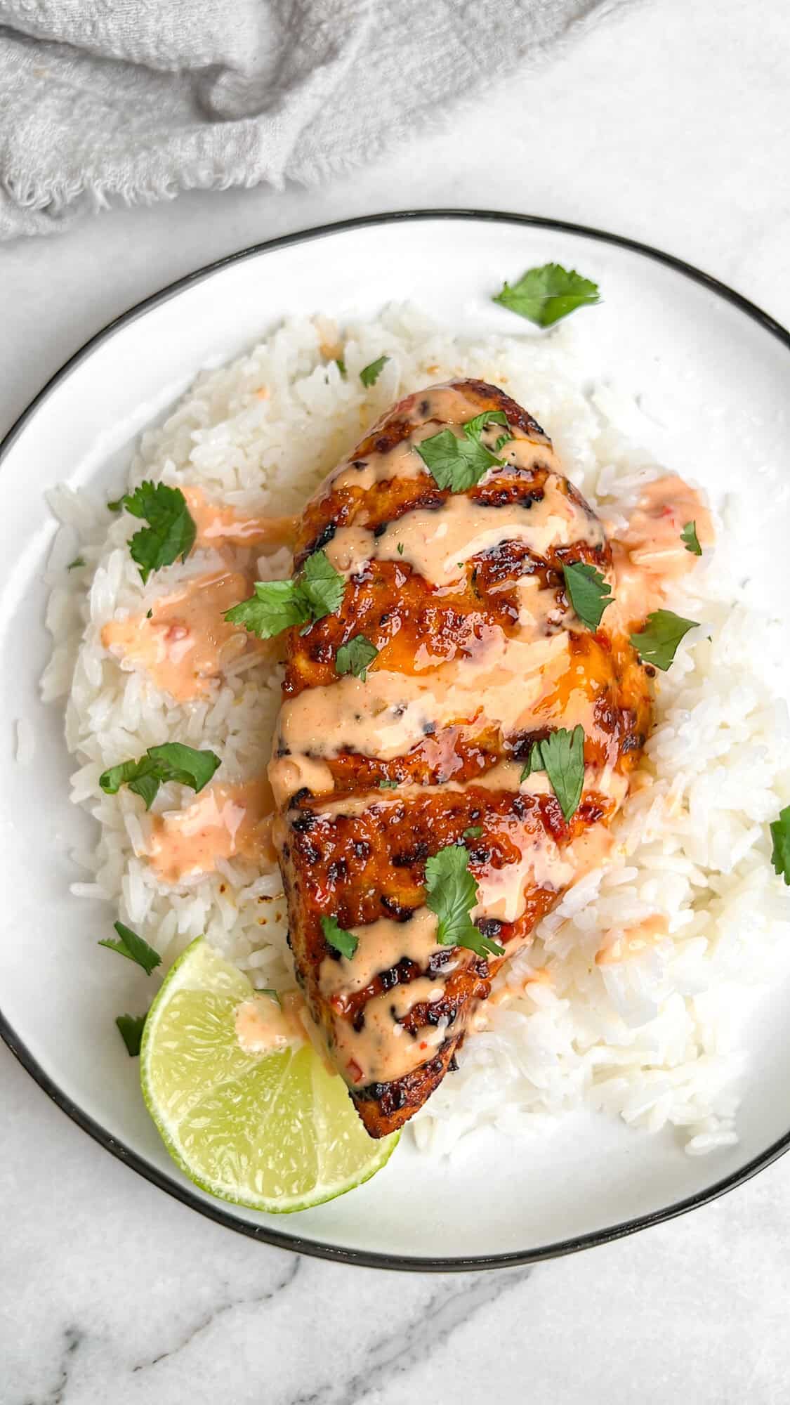 This air fryer bang bang chicken is tender, juicy, and so flavorful. The best part? It's ready in just 25 minutes! Overhead view of bang bang chicken on a plate over rice