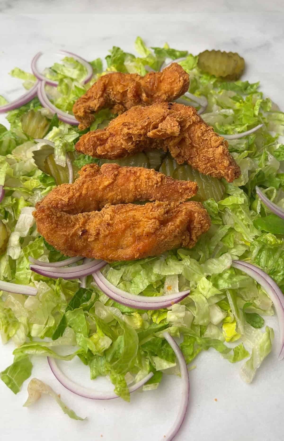 chopped chicken sandwich ingredients on a cutting board