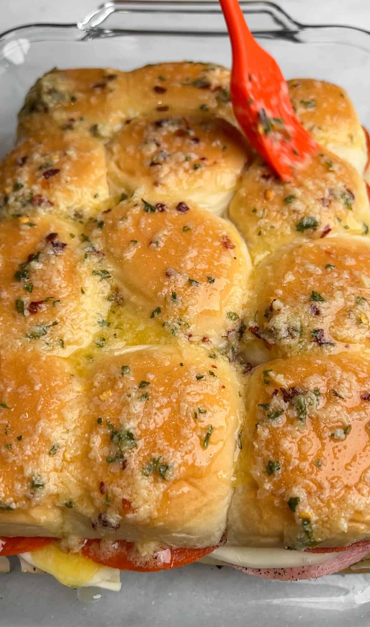 brushing the top buns with garlic butter