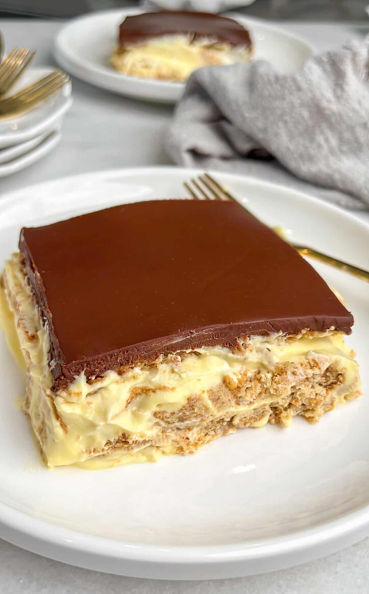 no bake eclair cake sliced on a plate with a gold fork
