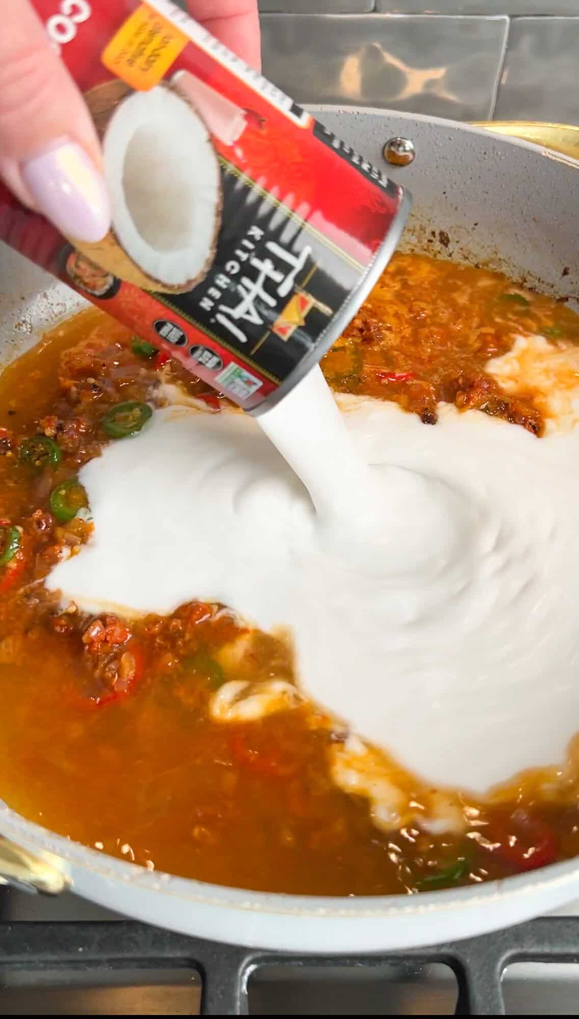 adding coconut milk to the brothy rice