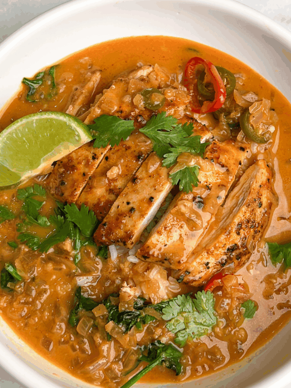 bowl of thai coconut brothy rice with a lime wedge on top