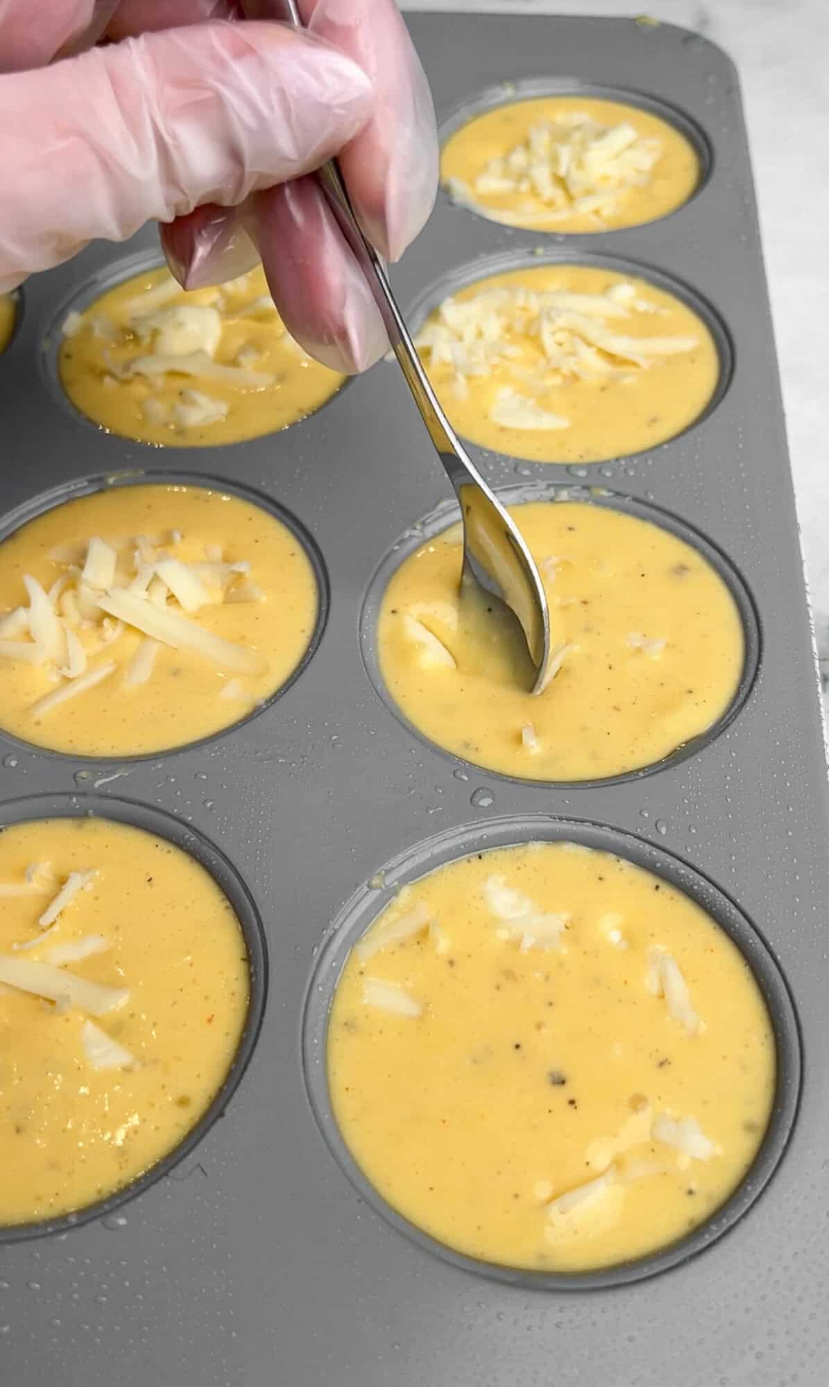 pushing cheese to the center of the egg bites with a spoon