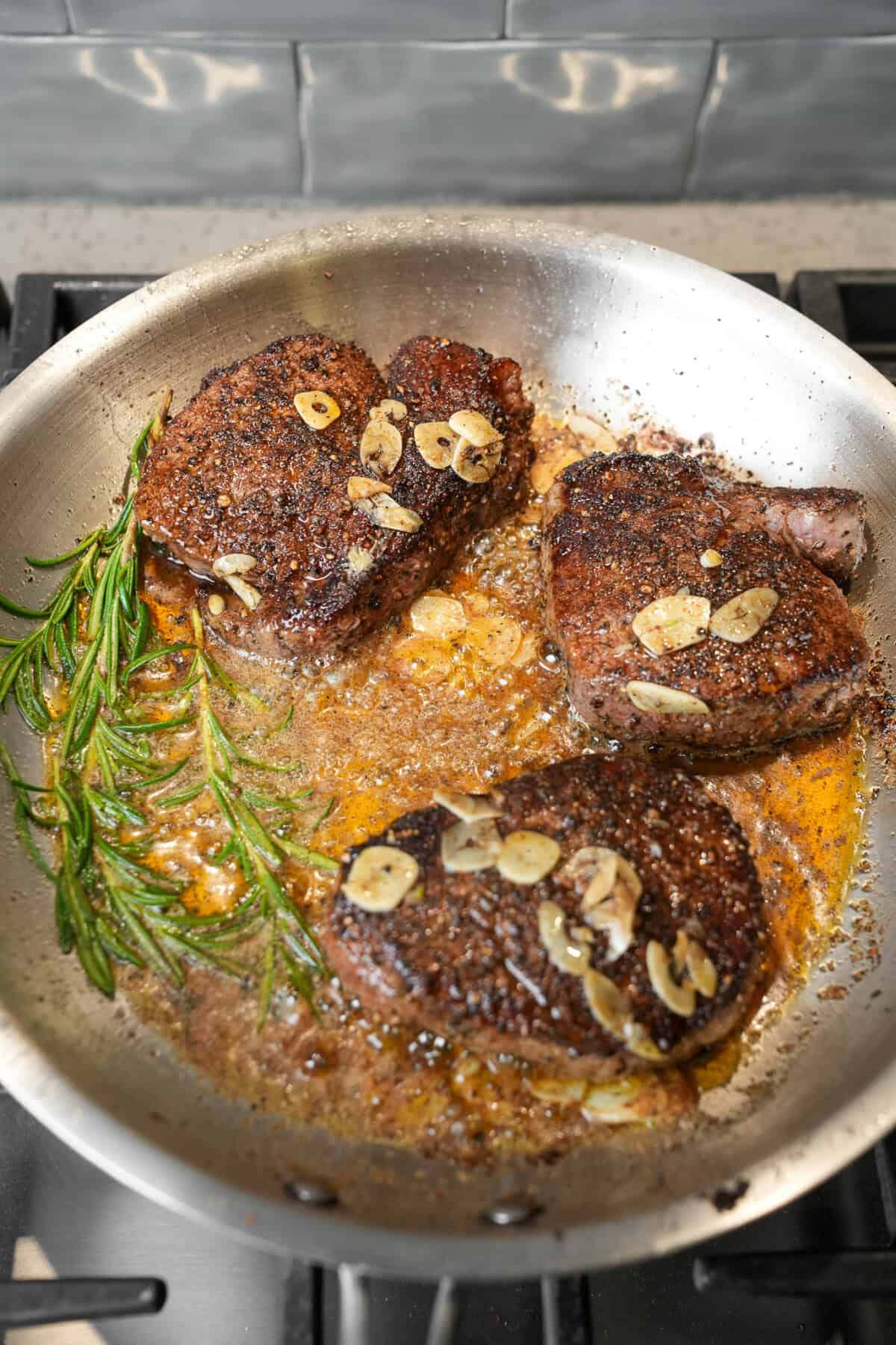 basting the seared steaks