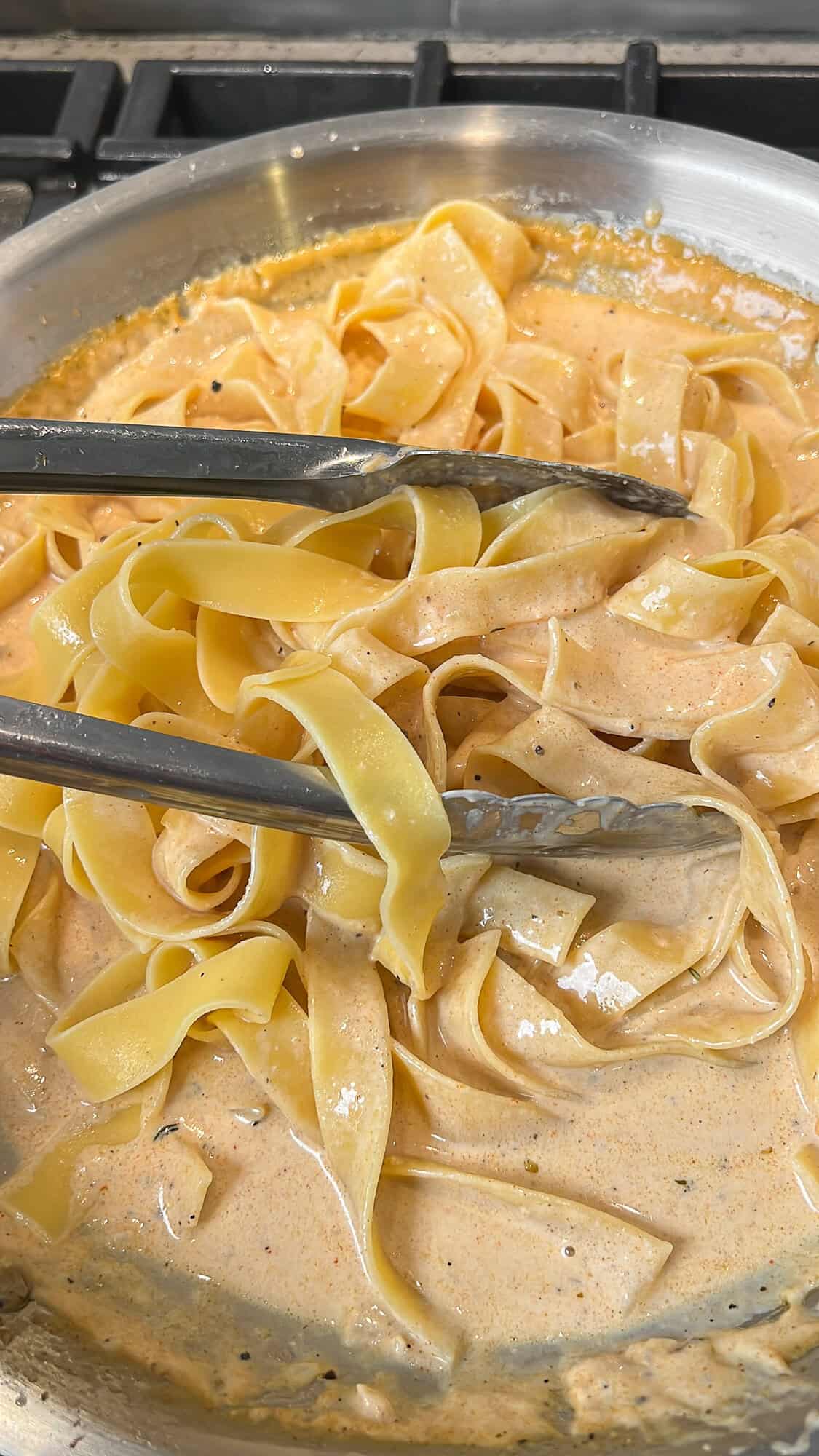 Noodles are tossing in creamy pasta sauce