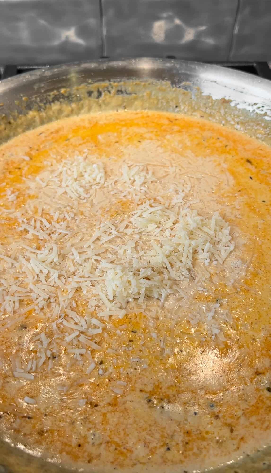 adding parmesan to the cream sauce
