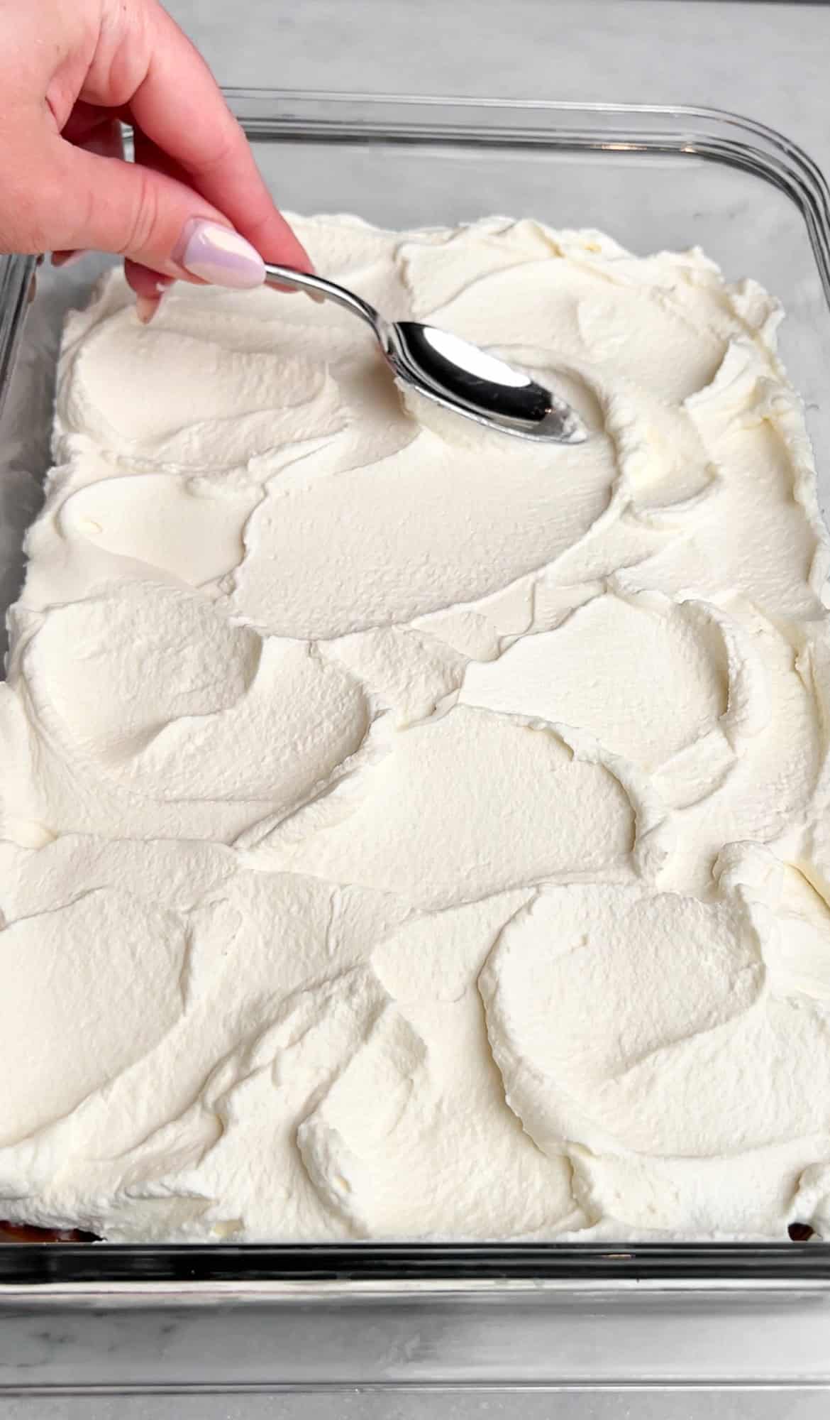 Spreading the whipped cream layer onto the oreo delight