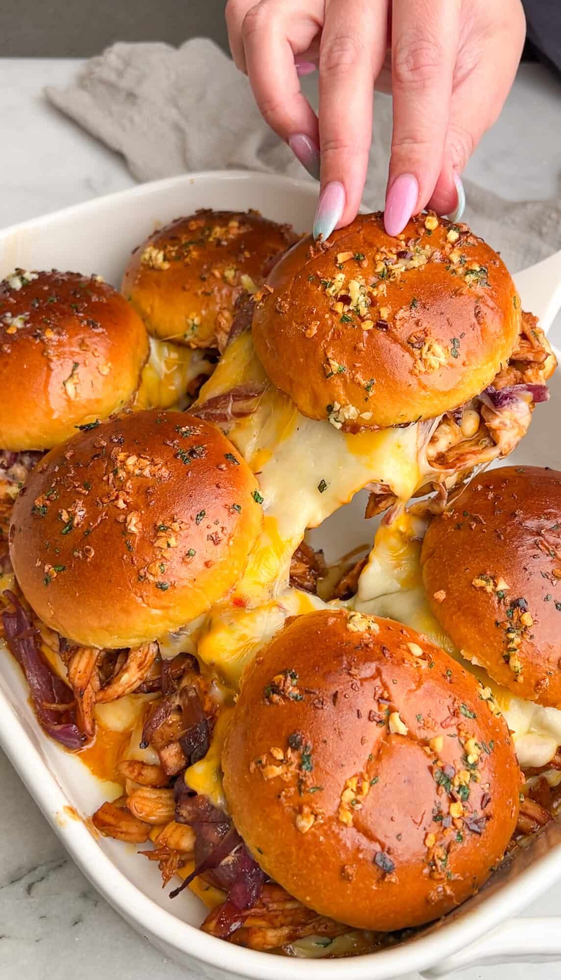 bbq chicken sandwich being lifted off the pan with a cheese pull