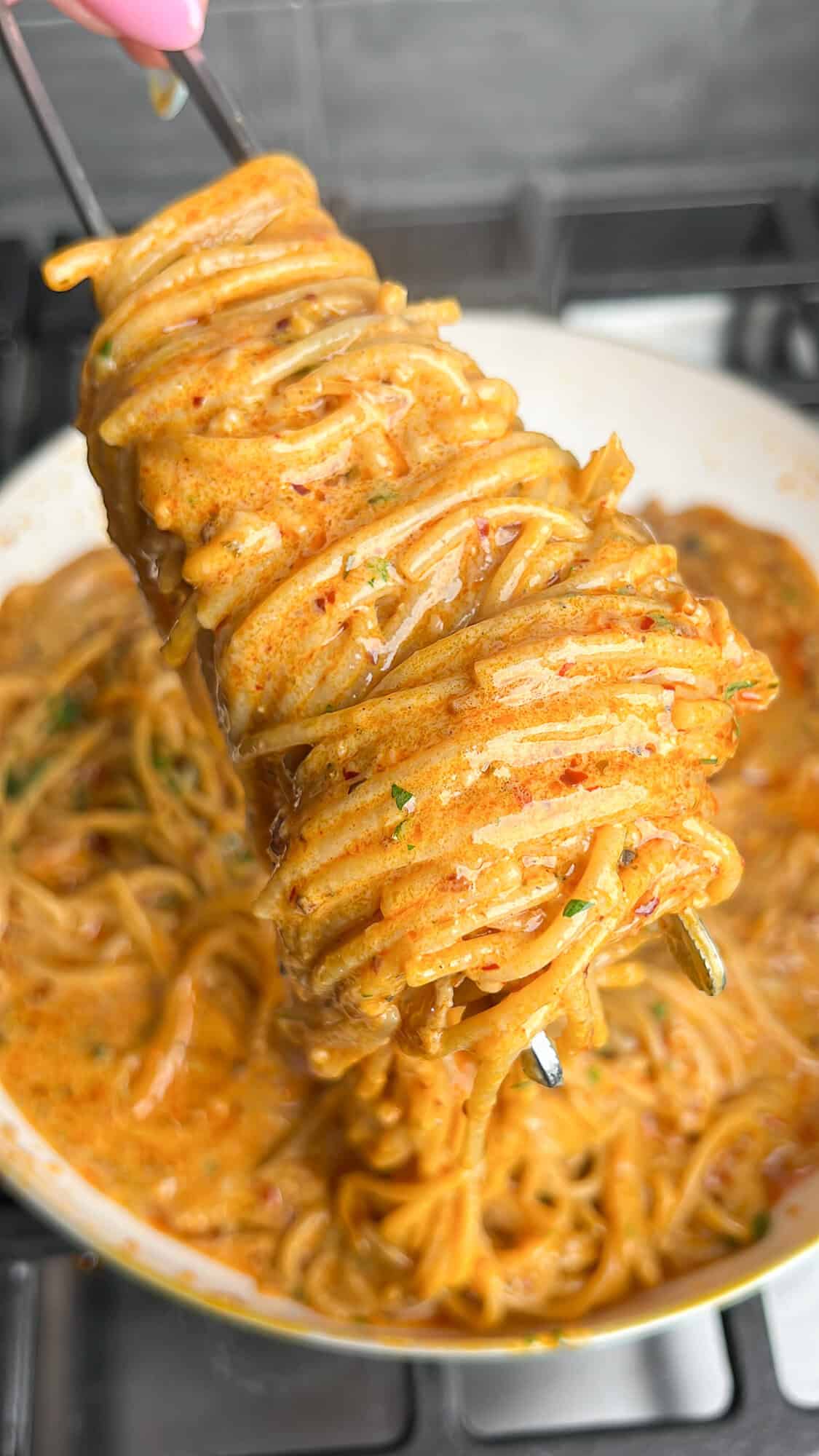 caramelized onion pasta twirled on tongs