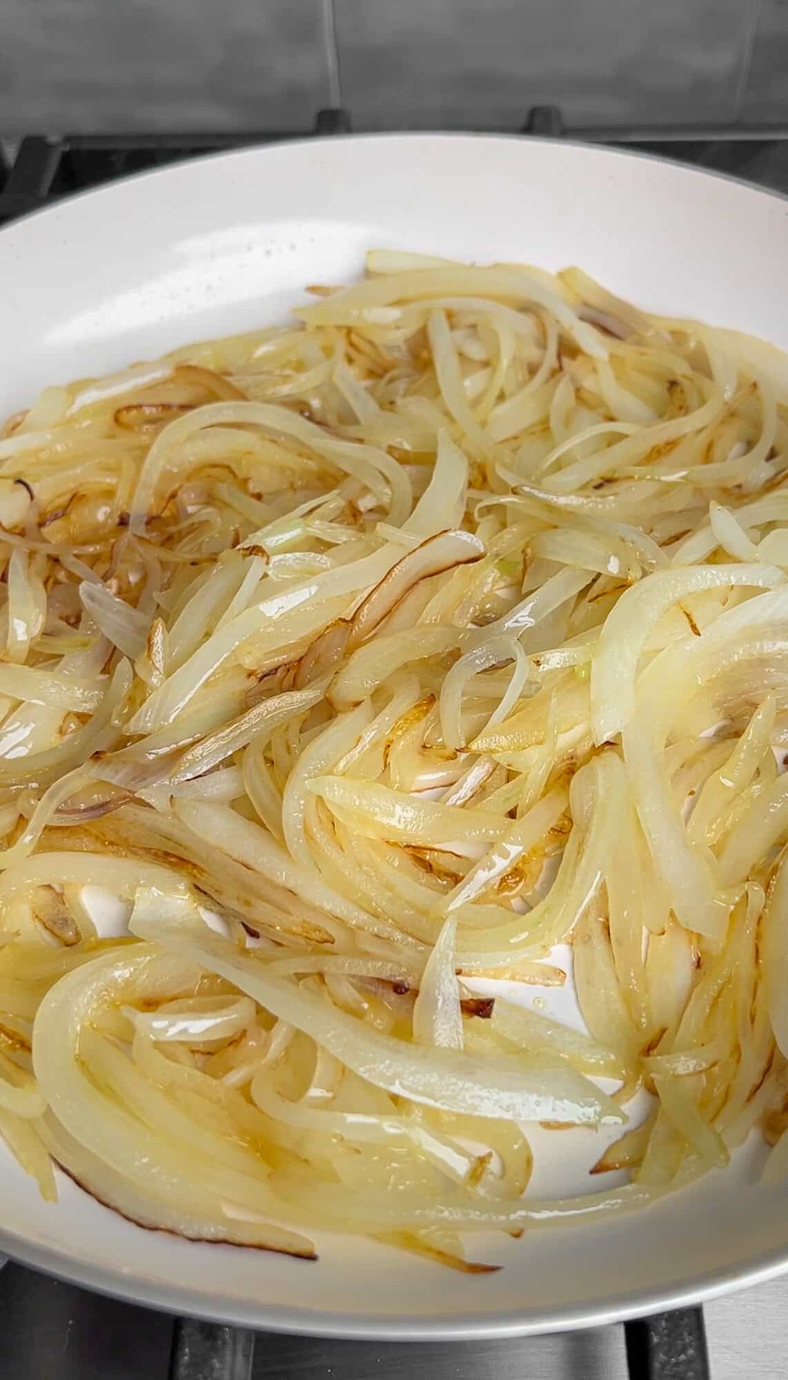 thinly sliced onions in a pan with butter