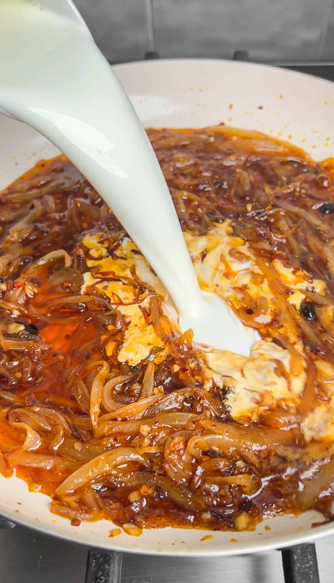 adding half and half to the caramelized onion pasta sauce