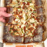 a slice of pickle pizza being grabbed by hand