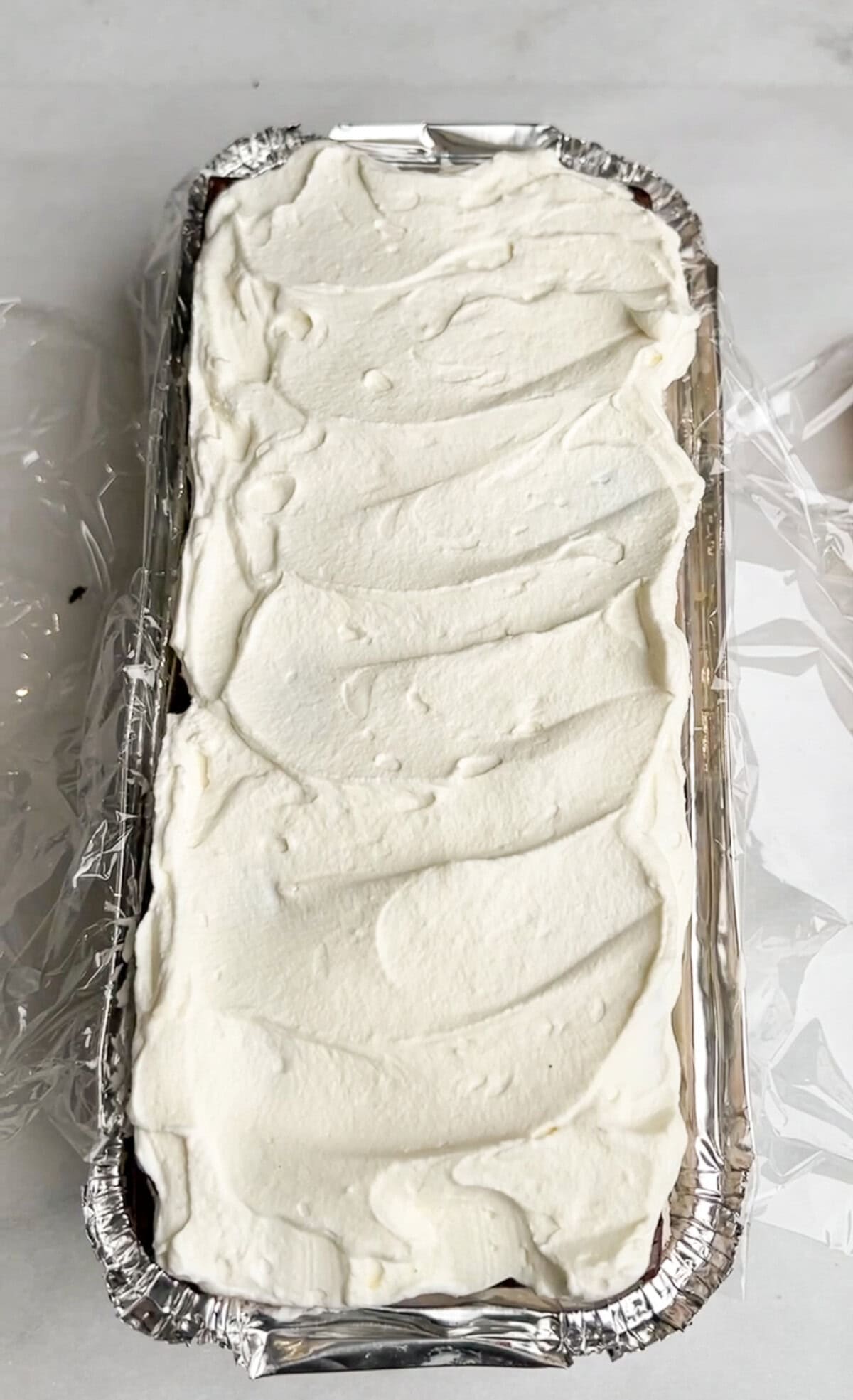 adding whipped cream to the ice cream sandwiches