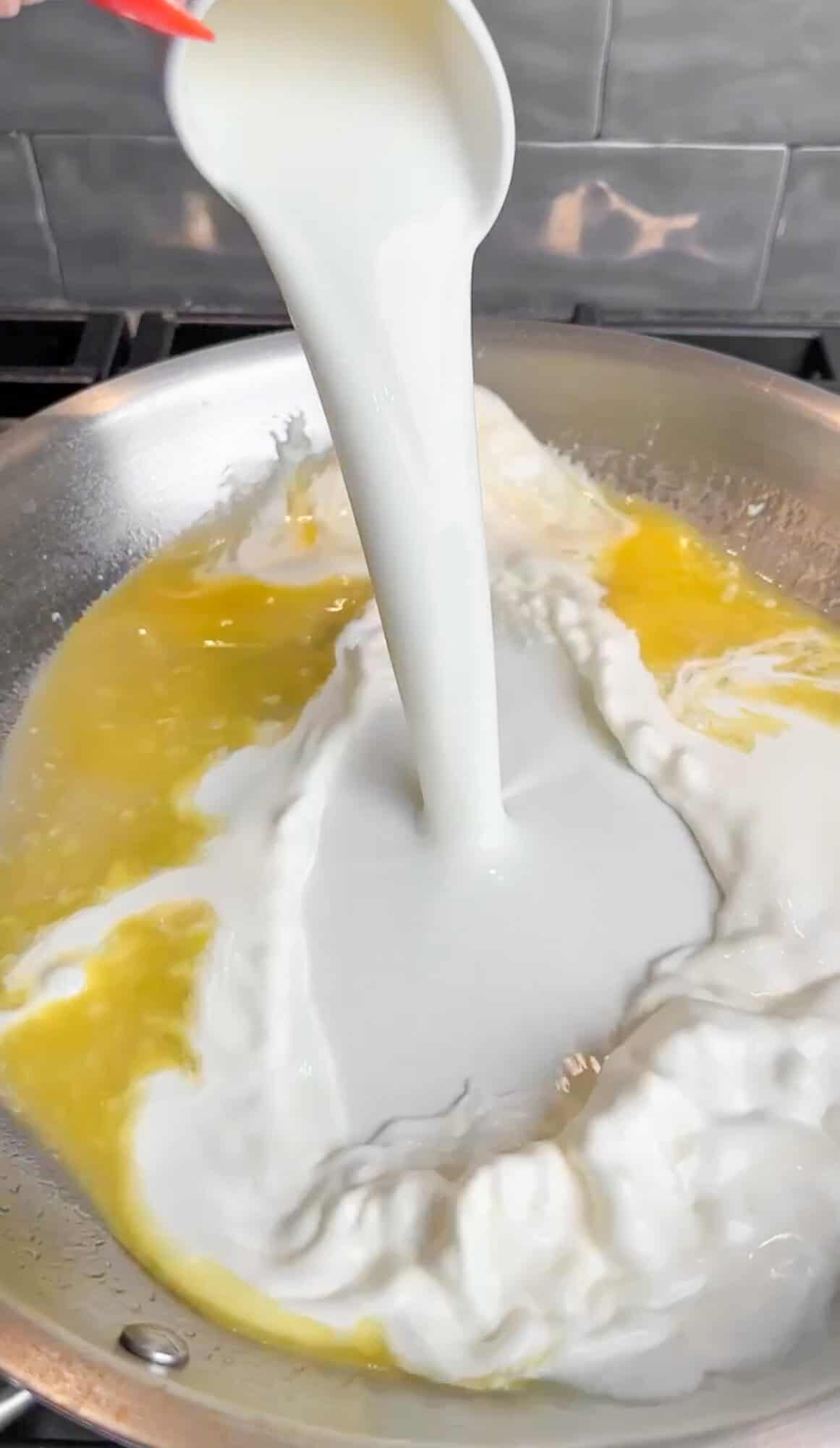 adding cream to the pasta sauce