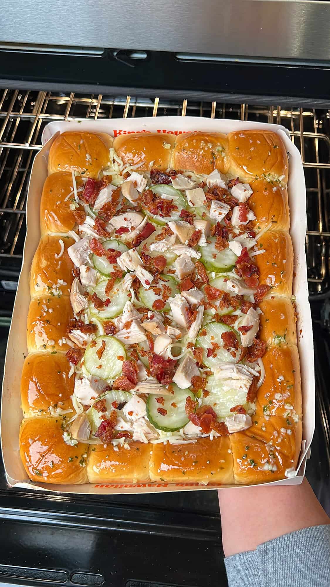 placing the hawaiian roll pickle pizza into the oven