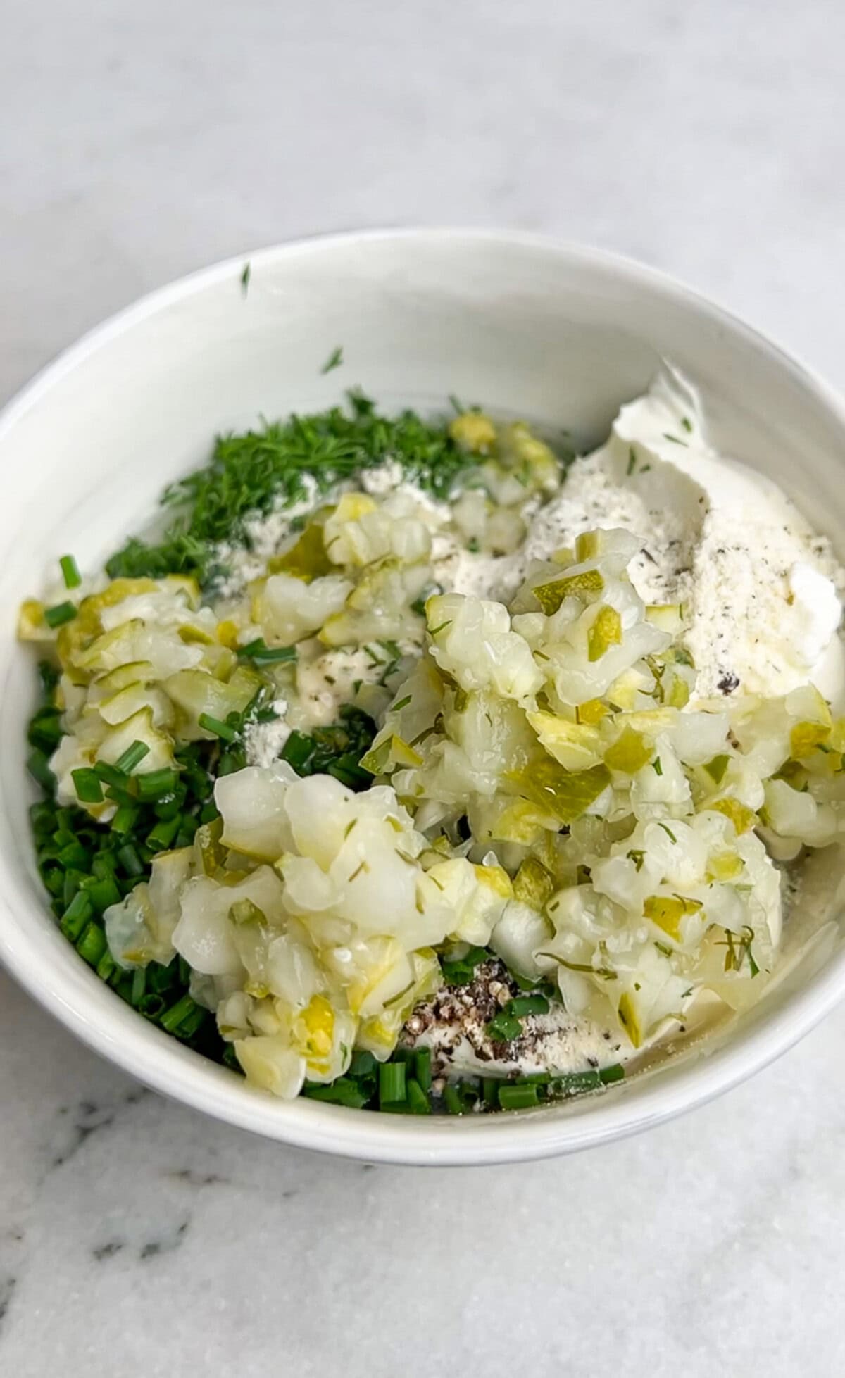 ingredients for dill pickle ranch dip in a bowl before being mixed together