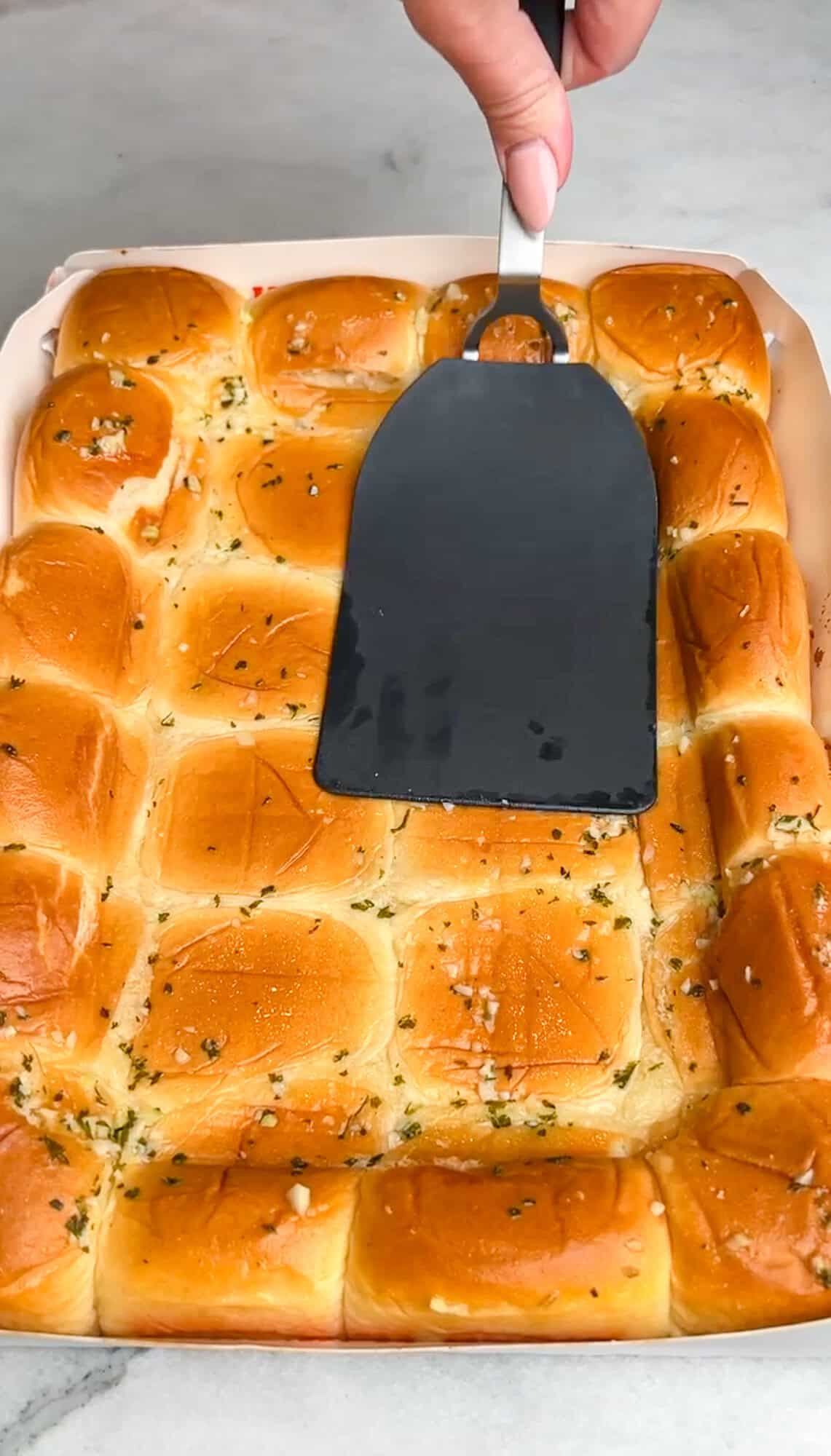 pressing down the rolls to define the crust and flatter the center