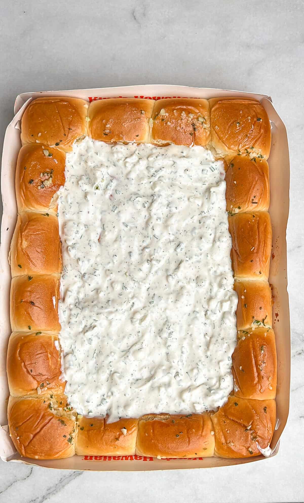 the ranch sauce layer spread onto the hawaiian roll crust