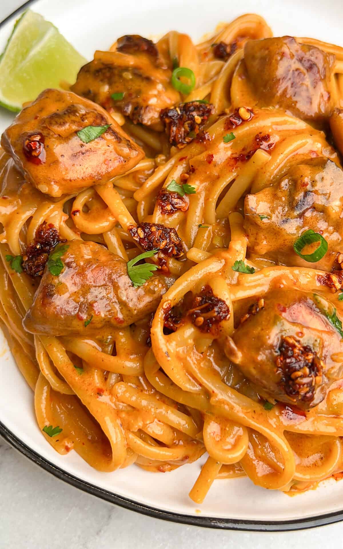 chili oil noodles on a plate with lime