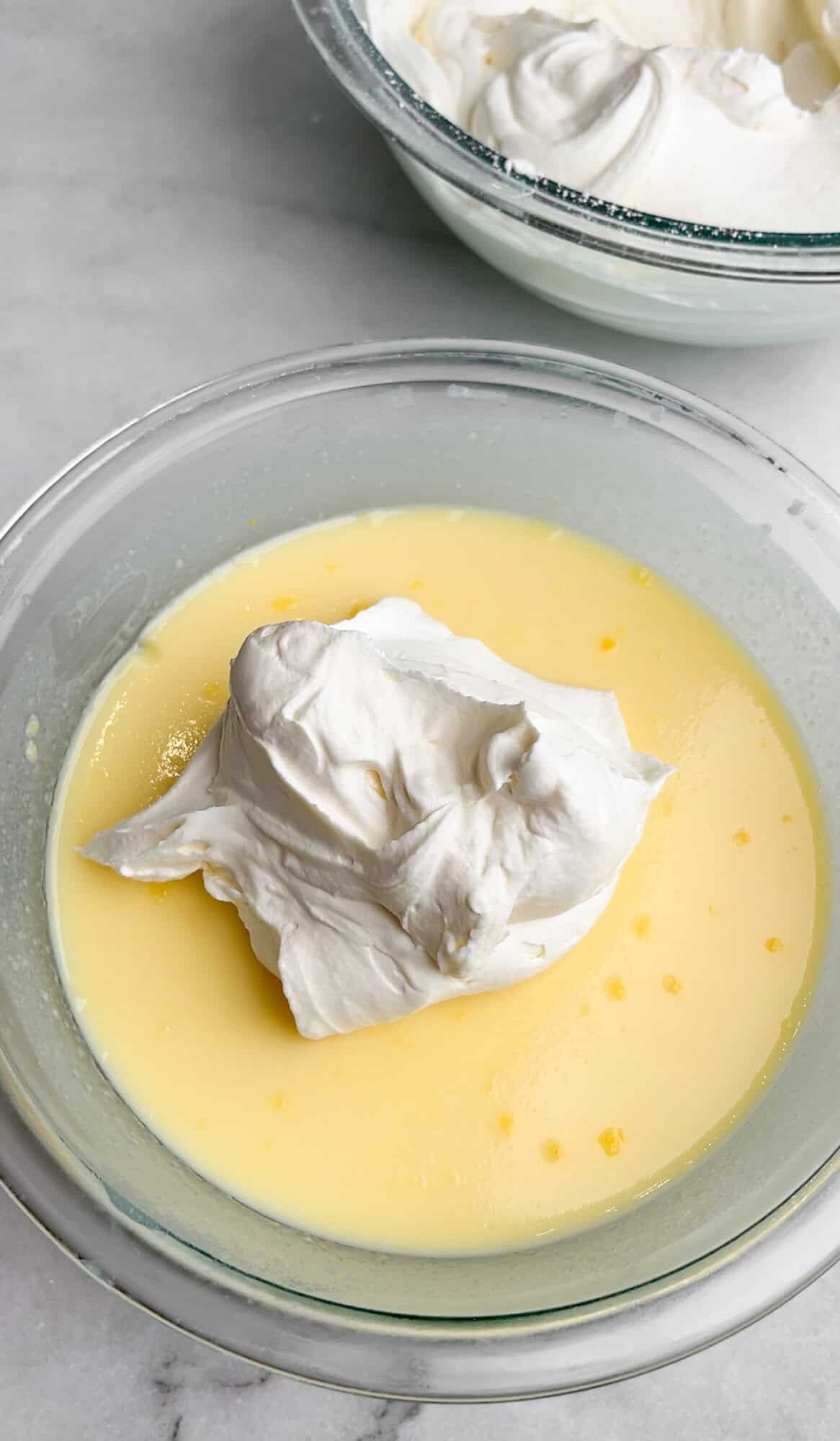 adding whipped cream to vanilla pudding