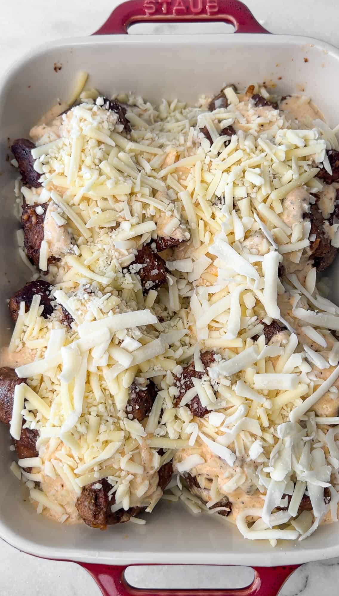 topping the steak loaded potatoes with cheddar cheese