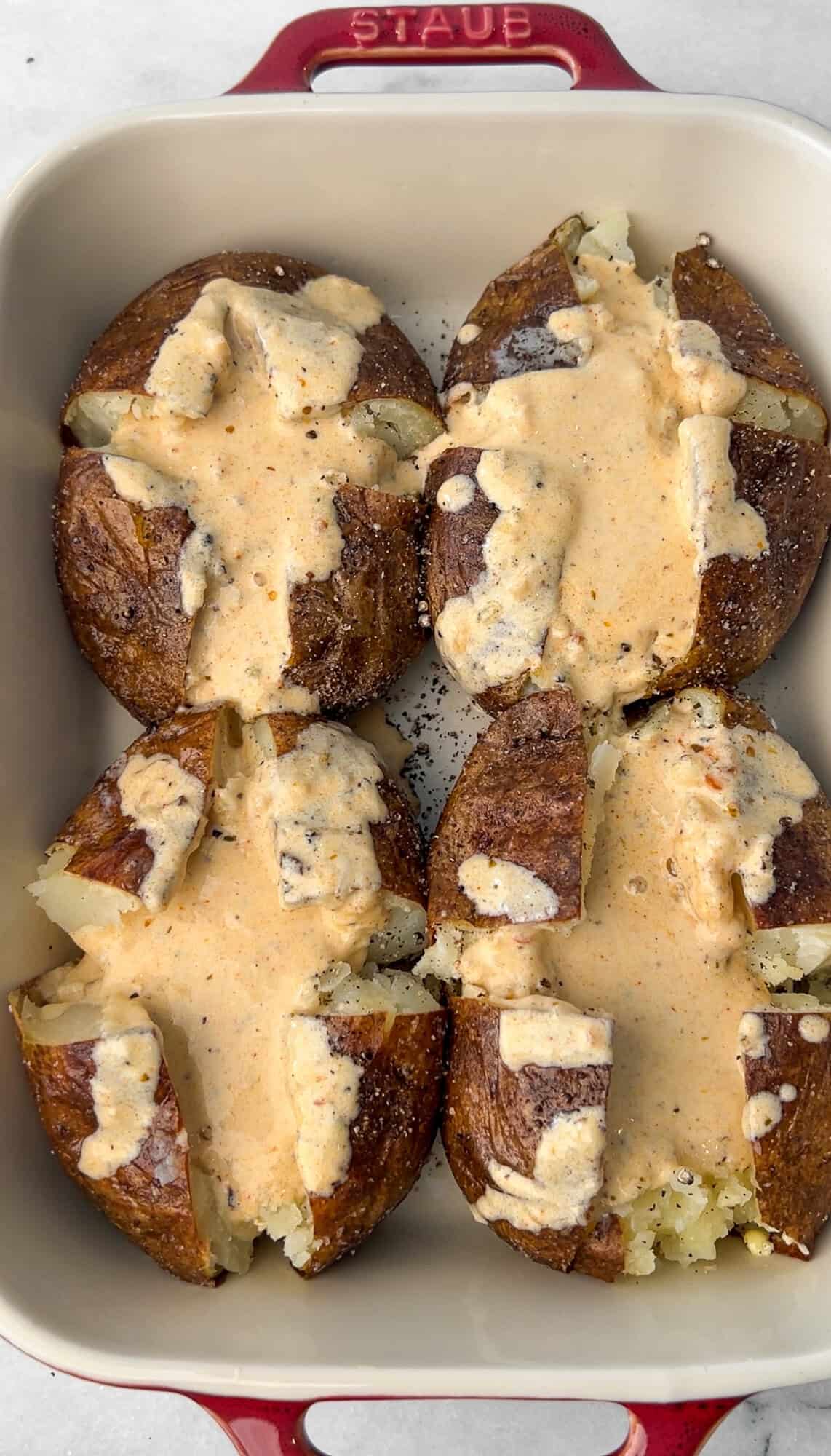 adding alfredo sauce to the potatoes