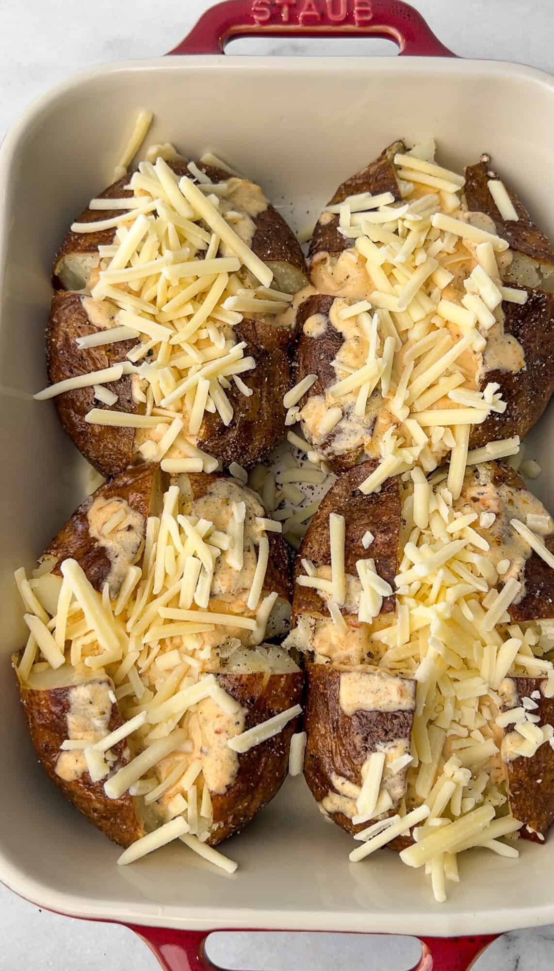 white cheddar adding to the baked potatoes
