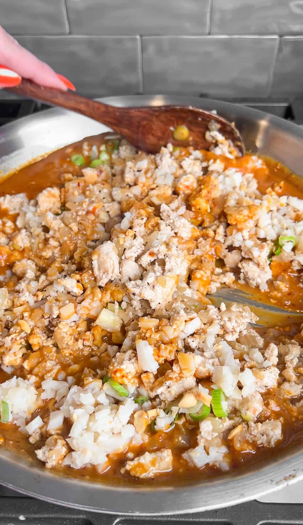 tossing ground chicken in peanut chili oil sauce