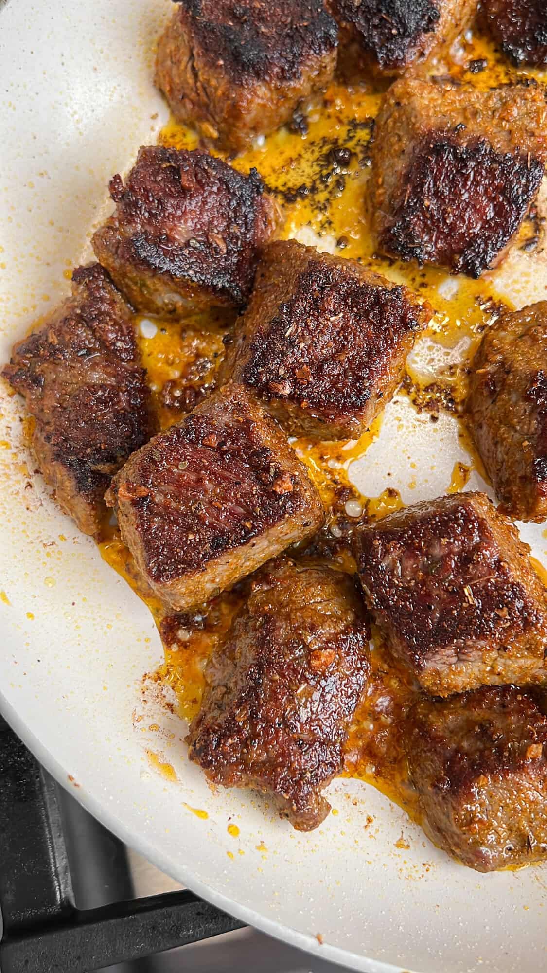 steak bites being seared in a pan