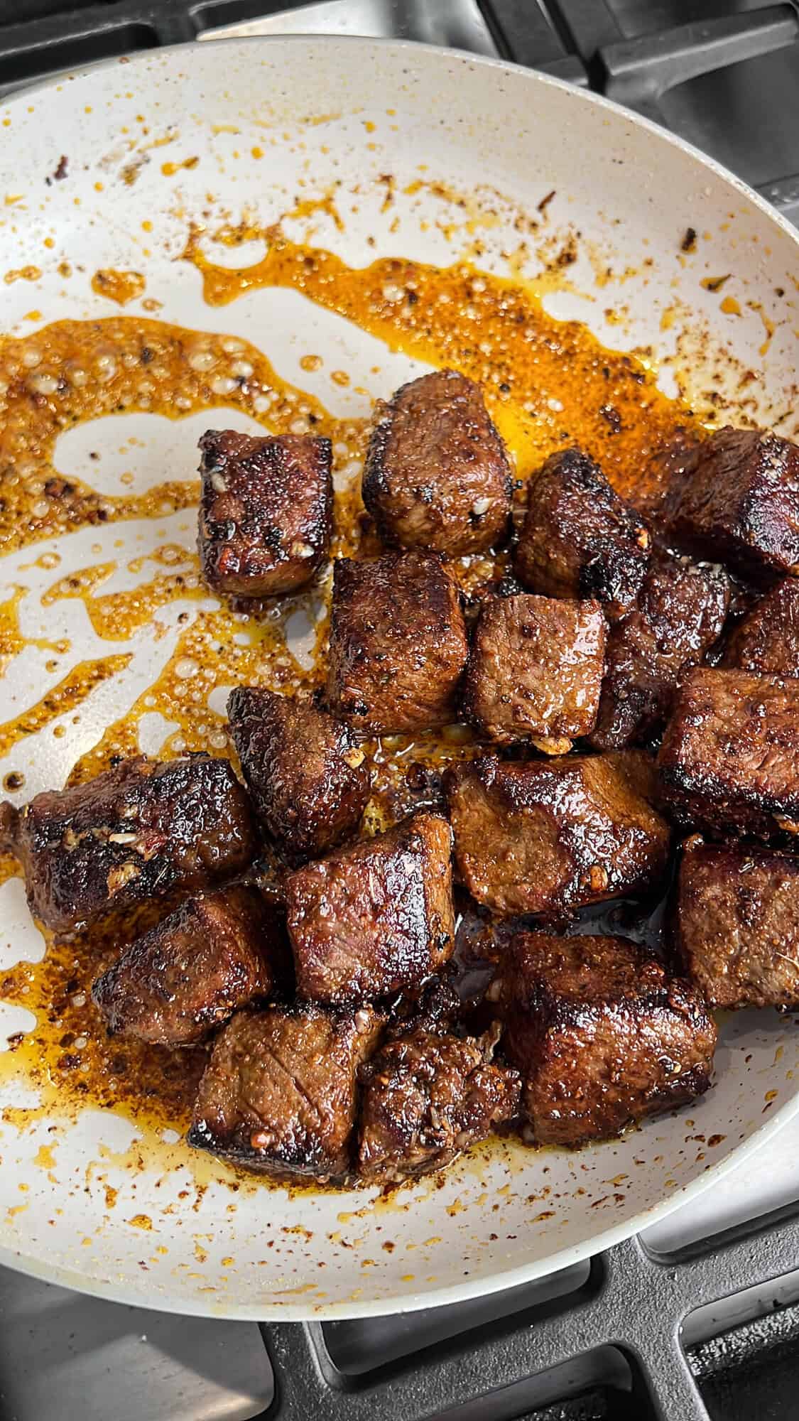 steak bites being seared in a pan
